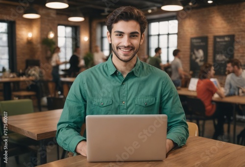 Young man with a laptop in a lively cafe. Radiating positivity with a modern and communal atmosphere.