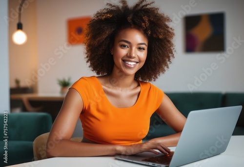 Radiant woman using laptop in a home setting. Energetic workspace with a comfortable and stylish look.