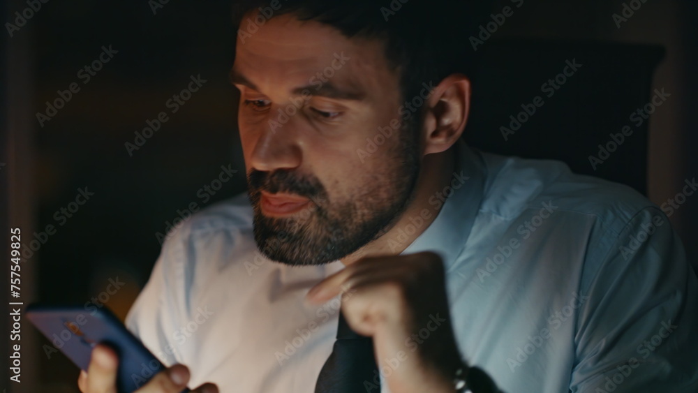 Anxious boss shouting smartphone loudspeaker recording message at night close up