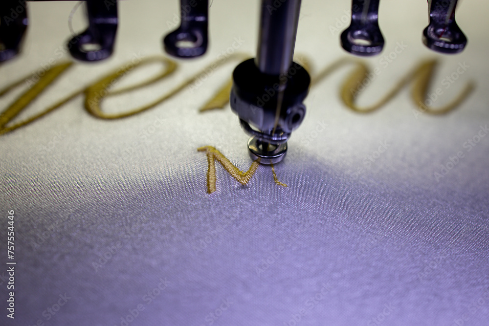 Embroidery text Mrs with gold thread on a white satin robe for the bride. Embroidery text Mrs with gold thread on a white satin robe for the bride.