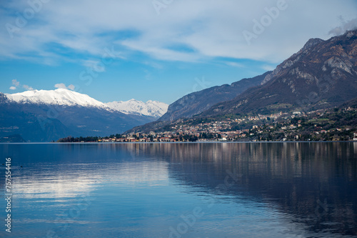 Driving car along shores of Lake Como in Northern Italy  spring sunny days  views of alpine mountains  water and villages