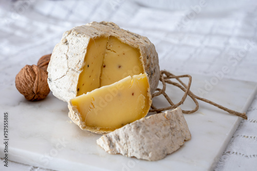 Italian hard cheese truffelino romano with black summer truffles mushrooms close up