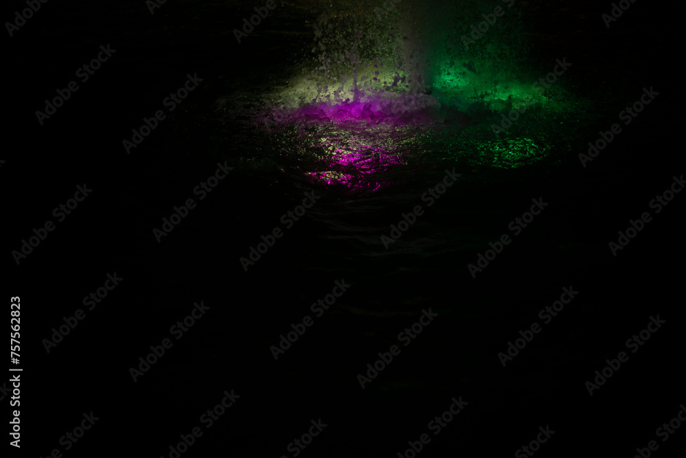 Colored fountain at night. Illumination of water on the fountain. Water in the evening.