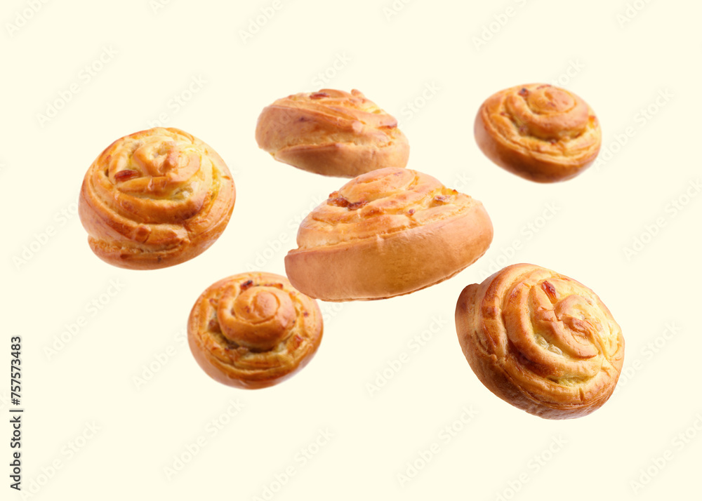 Sweet buns. Delicious rolls with raisins falling on beige background