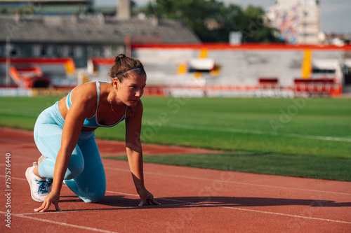 Female runner getting ready to start a race at the stadium