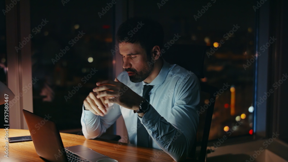 Worried manager sitting night workplace looking laptop close up. Worker tired 