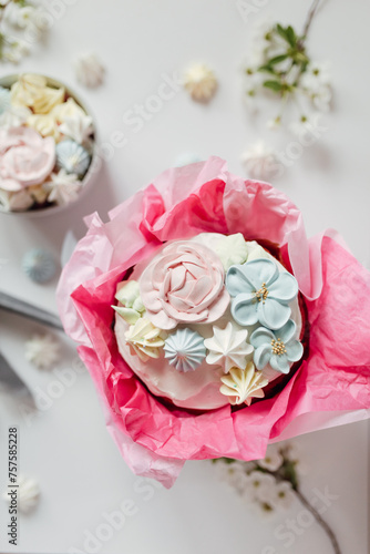 Festive Easter table in delicate colors  cake decorated with meringue  icing  flowers. Sweets in the form of flowers  apple blossoms  Easter eggs.