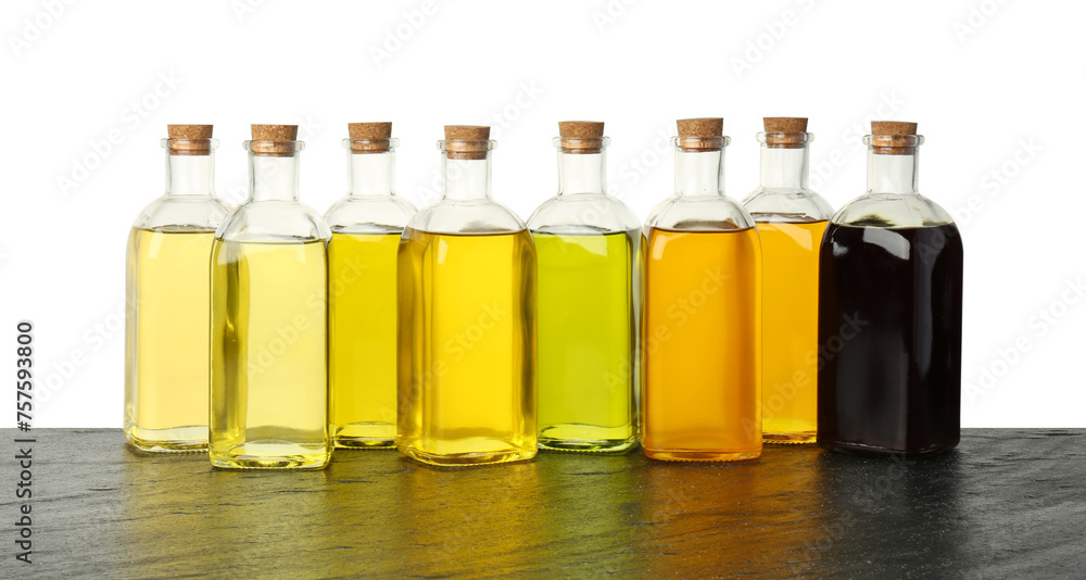 Vegetable fats. Bottles of different cooking oils on wooden table against white background Vegetable fats. Bottles of different cooking oils on wooden table against white background