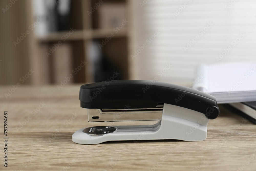 One stapler on wooden table indoors, closeup One stapler on wooden table indoors, closeup