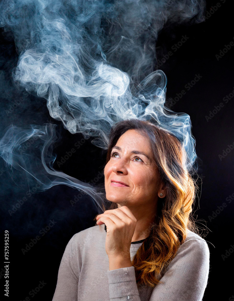 Mature woman with smoke coming out of her head from thinking so much. Isolated on black background.