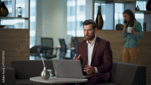 Confident ceo conducting video meeting with partners sitting office in suit