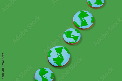 Earth Day concept. Сookies in shape of Earth on green backdrop. Copy space.