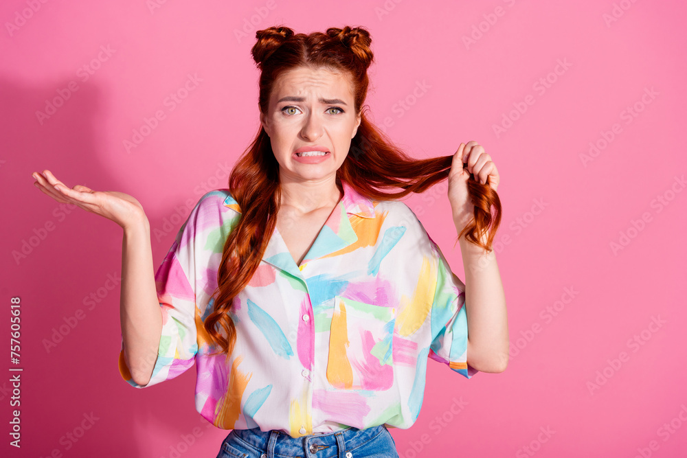 Portrait of clueless confused woman wear print shirt hold foxy hair think to cut curl shrug shoulders isolated on pink color background Portrait of clueless confused woman wear print shirt hold foxy hair think to cut curl shrug shoulders isolated on pink color background