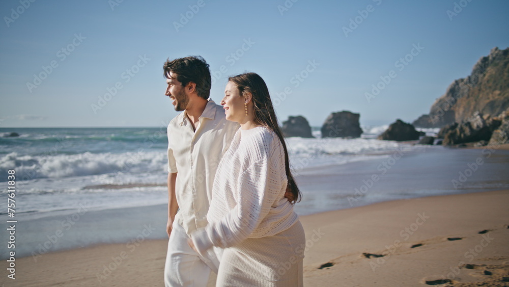 Pregnant woman strolling man on beach at family vacation close up. Happy spouses