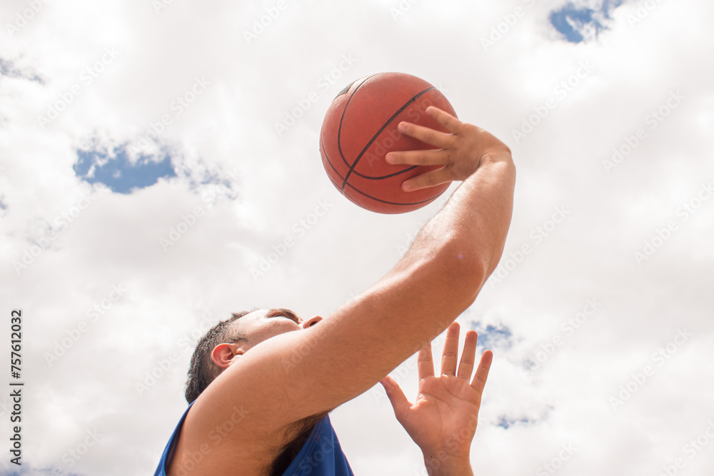 Low angle of Man training basketball in court at summer Low angle of Man training basketball in court at summer