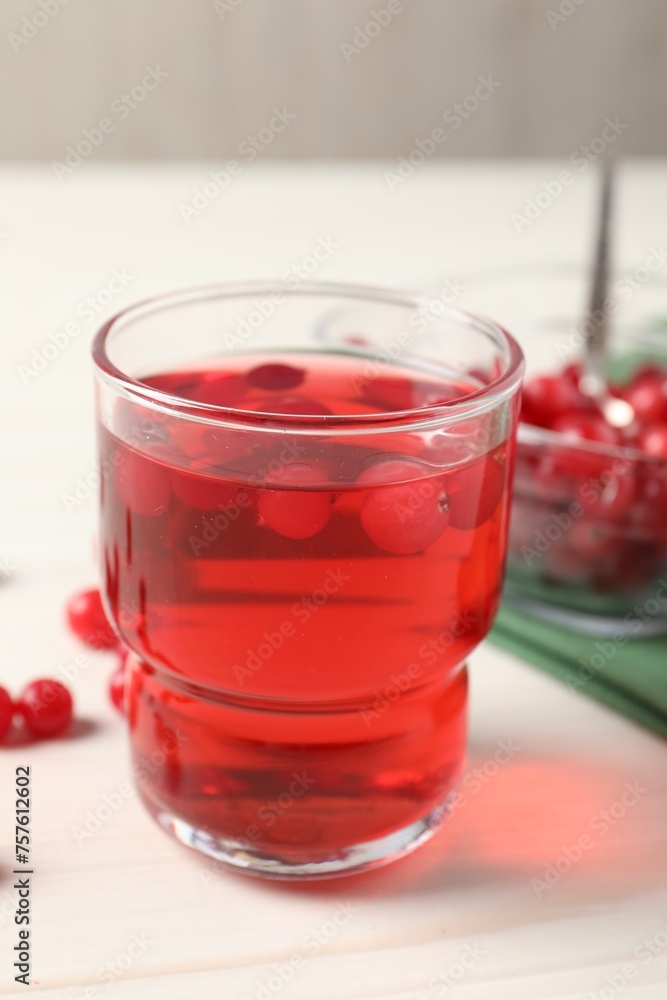 Tasty cranberry juice in glass and fresh berries on white wooden table, closeup Tasty cranberry juice in glass and fresh berries on white wooden table, closeup