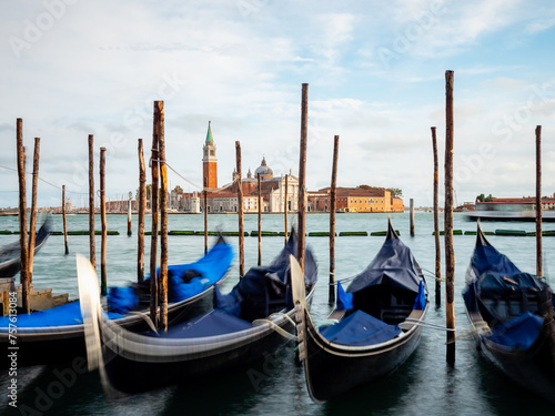 Gondolas moored by Saint Mark square with San Giorgio di Maggiore church in Venice, Italy © eplisterra