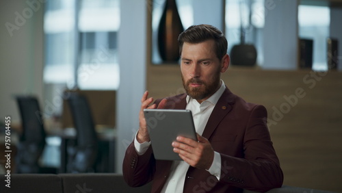 Focused lawyer looking tablet computer screen at corporate financial cabinet
