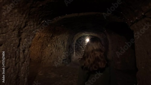 A woman walks in narrow tunnels of the Derinkuyu underground city built in BC 1200 in Cappadocia, Turkey.