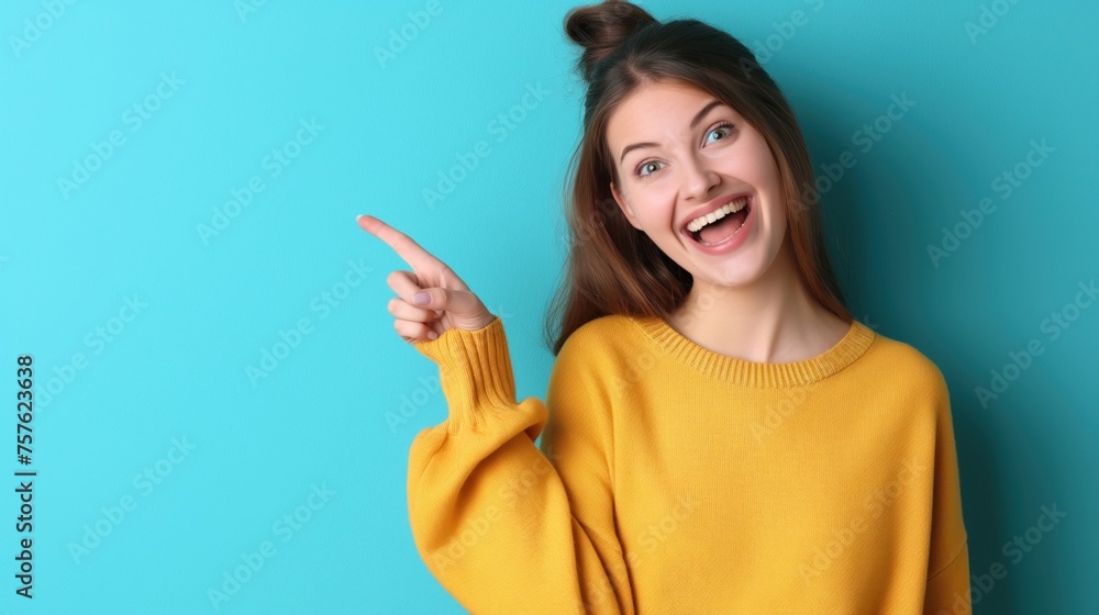 Fototapeta premium oung woman isolated on blue background pointing to a copy space, expressing excitement and desire