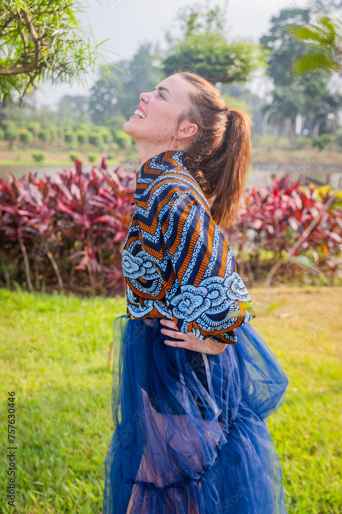Smiling girl looks at the sky while wearing African dress Smiling girl looks at the sky while wearing African dress