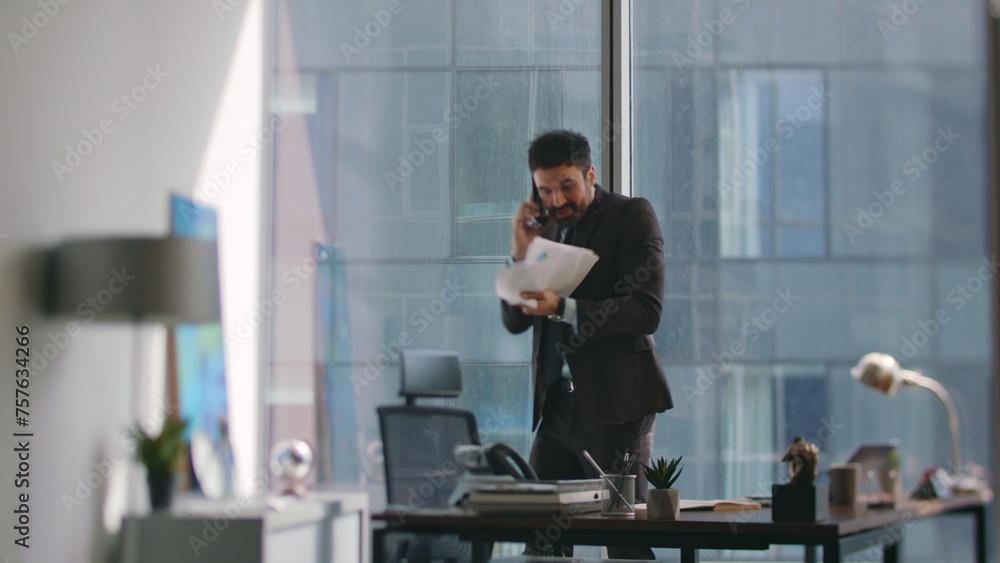 Laughing broker calling phone standing office. Happy ceo throwing papers up Laughing broker calling phone standing office. Happy ceo throwing papers up