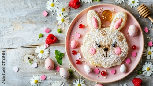 Cute easter bunny pancake breakfast with berries, honey, and pastel eggs on wooden background