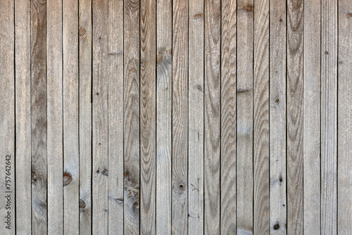 The image is a close up of a wooden wall with a grainy texture