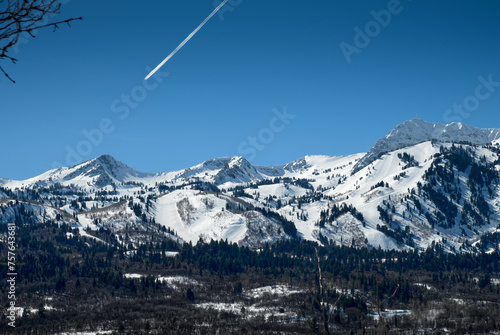 A jetliner with its contrail above Snowbasin ski resort near Ogden, Utah. The photograph was taken from the Wheeler Creek Trail.