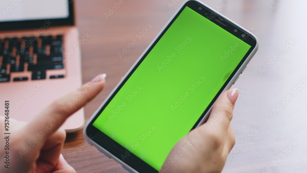 Girl hands swiping green screen telephone looking phone number in office closeup Girl hands swiping green screen telephone looking phone number in office closeup