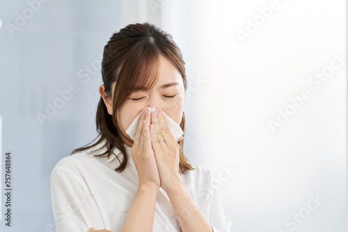 鼻炎で鼻をかむ女性