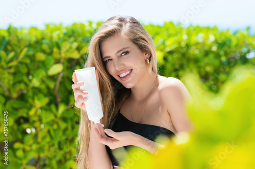 Beautiful woman with bottle of cosmetic products. © Volodymyr