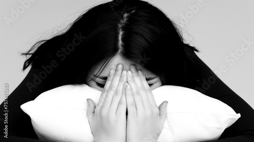 Woman on pillow covering face with hands