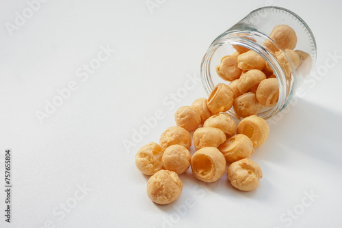 Kue soes kering, delicious cheese soes cake coming out of an upside down glass jar isolated on white background photo