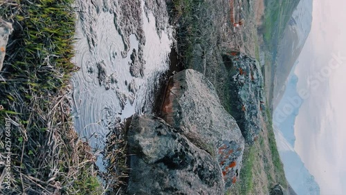 Narzan drinking spring in Ossetia. The bubbling water of a natural mineral spring against the background of a red rocky bottom. The healing water of the Narzan Valley. North Caucasus, Russia. 4K photo