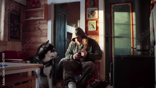 The Man is Petting His Dog While Enjoying a Drink During Winter in Bessaker, Trondelag County, Norway - Static Shot photo