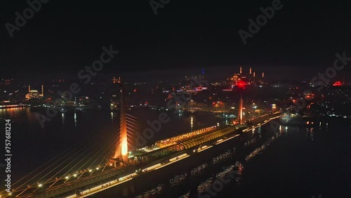 Drone flight around illuminated cable-stayed metro bridge in Istanbul at night, Haliç station connecting Eminönü and Beyoğlu districts photo