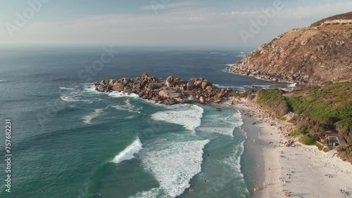 Cape Town, South Africa - Tourists Savoring the Frothy White Waves During Their Vacation at Llandudno Beach - Aerial Drone Shot