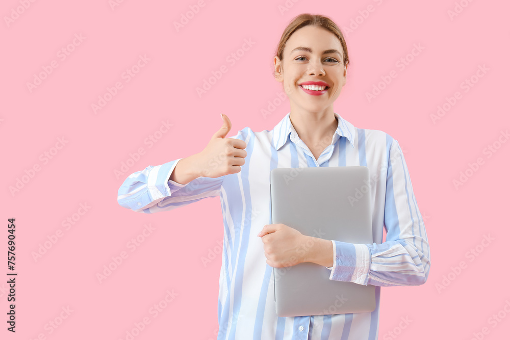 Female programmer with laptop showing thumb-up on pink background Female programmer with laptop showing thumb-up on pink background