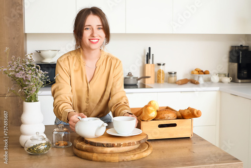 Young woman with teapot at ...