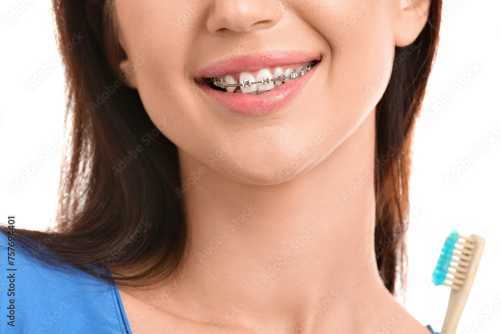 Young woman with dental braces and toothbrush on white background, closeup Young woman with dental braces and toothbrush on white background, closeup