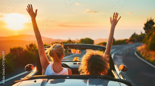 Couple on vacation on the roadtrip having fun driving a convertible car raising the arms to the sky. 