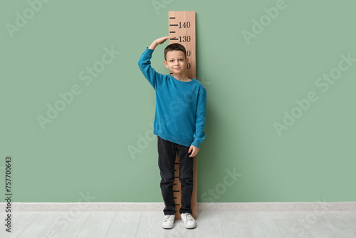 Cute little boy measuring h...
