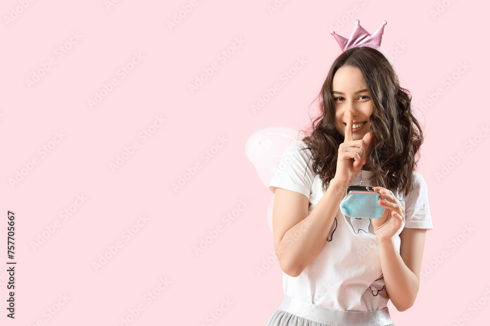 Tooth Fairy with wallet showing silence gesture on pink background Tooth Fairy with wallet showing silence gesture on pink background