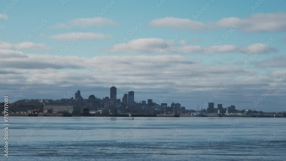 Quebec City's skyline with blue sky and clouds, the majestic St. Lawrence River in the foreground Quebec City's skyline with blue sky and clouds, the majestic St. Lawrence River in the foreground