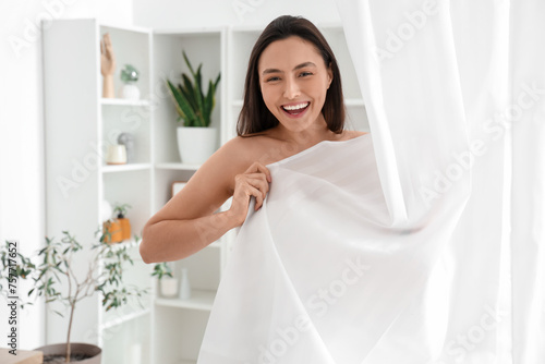 Young woman behind curtain taking bath at home