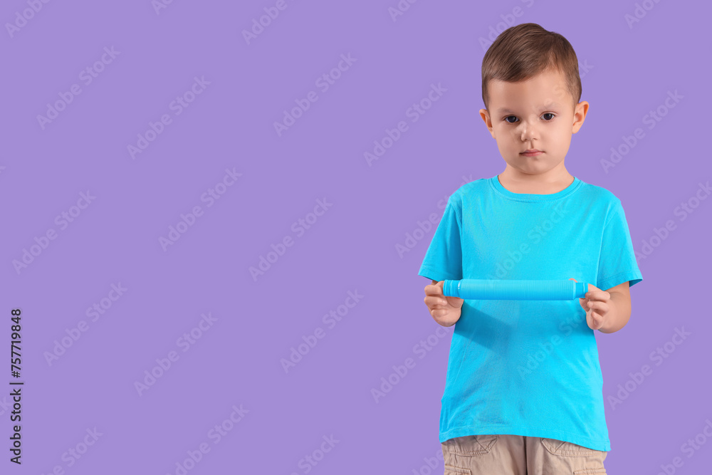 Little boy with autistic disorder and Pop Tube on lilac background Little boy with autistic disorder and Pop Tube on lilac background