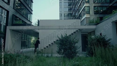 Business man in suit rushing up the office stairs because he is running late photo