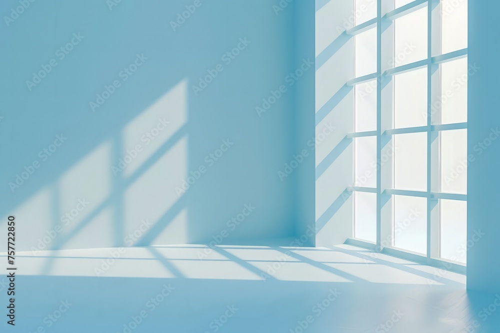 Fototapeta premium A room with a window casting shadows on a light blue wall, creating a minimalist and abstract atmosphere for product presentation