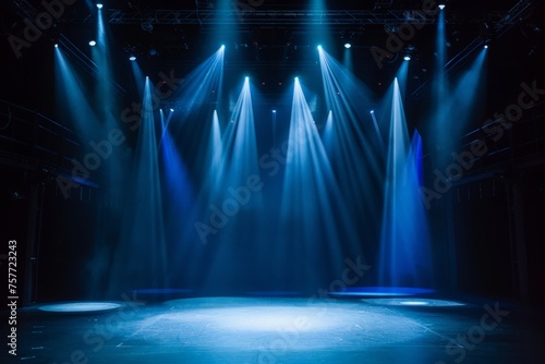 A stage with blue lights and a circular floor, set up for a modern dance production. The spotlight illuminates the empty stage, creating a dynamic backdrop for an entertainment show